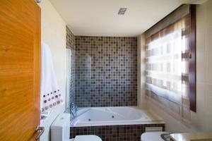 łazienka z wanną, toaletą i umywalką w obiekcie APARTAMENTOS DE CANELAS SUITES con AMPLIAS TERRAZAS w mieście Portonovo +37 zdjęć