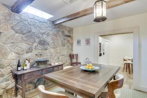 une salle à manger avec une table en bois et un mur en pierre dans l'établissement French Château Near Beaches, Mystic and Casinos!, à Stonington 24 autres photos