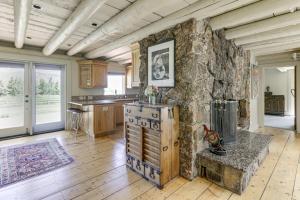 a large kitchen with a stone wall and a table at Snowmass Home with Hot Tub, Fireplace, and Mtn Views! in Snowmass
