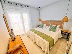 a bedroom with two beds and a large window at Los Colibríes, Beach & Golf - By AC REAL in Isla Canela +46 photos