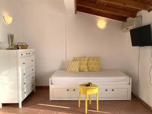 a small bedroom with a bed and a yellow stool at Heavenly View Yellow in Lákhion