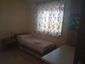 a small bedroom with two beds and a window at La Bombon era in Scalea