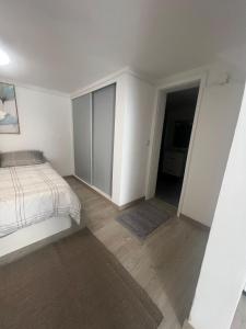 フンシャルにあるApartamento Santa Luciaの白いベッドルーム(ベッド1台付)、廊下