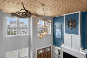een woonkamer met blauwe muren en een houten plafond bij Spoon Haven in Nags Head
