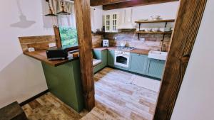 a small kitchen with green cabinets and a counter at Chata Prvosienka in Oravská Lesná