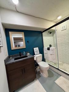 a bathroom with a toilet and a sink and a shower at The Monarch Unit 8 in Huntsville +14 photos