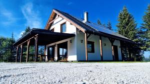 a white house with a black roof at Chata Prvosienka in Oravská Lesná