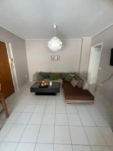 a living room with a couch and a table at Studios by the sea GREAT SUNSET in Kyparissia