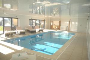 a large swimming pool in a large room with at Woodhouse Farm Lodge in Spalding