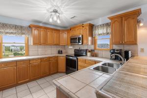 a kitchen with wooden cabinets and a sink at The Lily Pad in Nags Head +60 photos