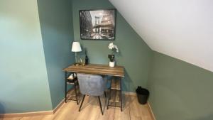 a small table in a room with a blue wall at Une parenthèse verte in Curgies