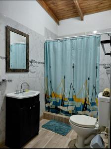 a bathroom with a toilet and a shower curtain at Caleta Olivia Ancla alojamiento departamento in Caleta Olivia +31 photos