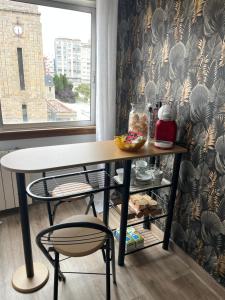 a table and a chair in a room with a window at Apartamento turístico A Coruña in A Coruña +3 photos