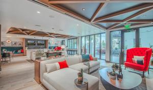 ロサンゼルスにあるModern 1BR Apartment with Pool, Hot Tub and Gym Access 10mins to Universal Studiosのリビングルーム(白いソファ、赤い椅子付)