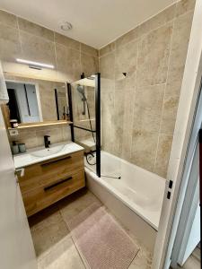 a bathroom with a tub and a sink and a shower at Évasion chic à Aucamville - Parking Privé - CLIM in Aucamville +6 photos
