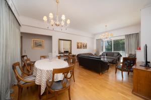 a dining room and living room with a table and chairs at Casa Tierra Near ATH Airport in Markopoulo