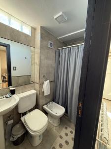 Un baño con inodoro, lavabo y ducha. en DepartamentoxdiaVD, en Villa Dolores