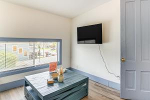 a living room with a coffee table and a flat screen tv at Less Than half Mi to The Strand Historic Galveston Apt! in Galveston