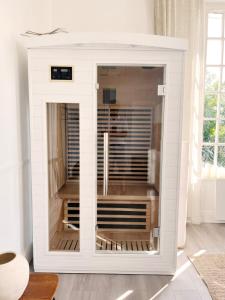 a white refrigerator in a room with a window at Charme, lumiere, jardin et sauna! in Étretat