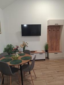 a dining room with a table and a tv on a wall at Domek u Oli - blisko Energylandia, Wadowice, Kraków, Oświęcim in Bachowice