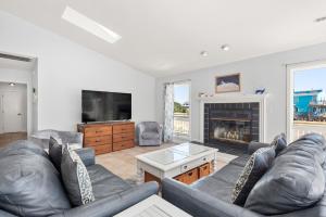 a living room with a couch and a fireplace at Wishing Whale in Corolla