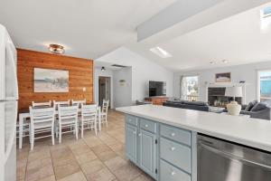 a kitchen and living room with a counter and chairs at Wishing Whale in Corolla