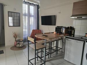 a kitchen with a small table and a kitchen with a stove at L'appartement au fauteuil relax in Viviers