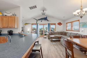 a kitchen and living room with a couch and a table at Marlin Manor by Village Realty in Nags Head