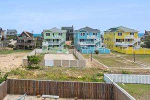 a group of houses on a beach with a fence at Marlin Manor by Village Realty in Nags Head