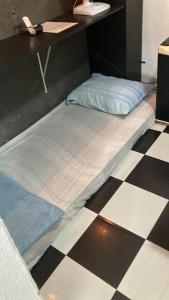 a bed sitting on top of a checkered floor at Peró Beach Hospedaria in Cabo Frio +9 photos