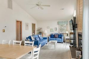 a living room with a blue couch and a table at My Happy Place by Village Realty in Corolla