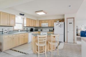 a kitchen with wooden cabinets and a white refrigerator at My Happy Place by Village Realty in Corolla
