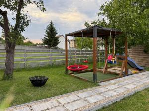 a playground with a swing set in a yard at Apartament Noclegi Tokarnia Duża 126 in Tokarnia