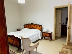 a bedroom with a large bed and a chair at Casa Vacanza Acquanuova in Calatafimi