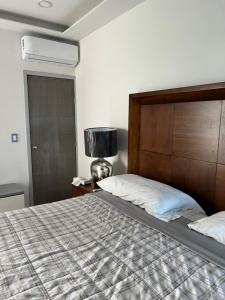 a bedroom with a large bed with a wooden headboard at Departamento en Marina Mazatlán in Mazatlán