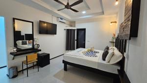 une chambre avec un lit, un miroir et un lavabo dans l'établissement Crown Beach Family villas, à Dhiffushi