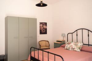 Un dormitorio con una cama, un armario y una silla. en La Stanzetta Rooms & Garden, en Casal Velino