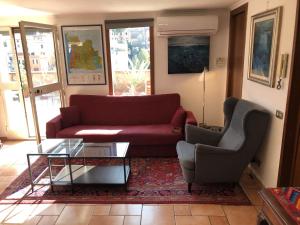 un soggiorno con divano rosso e sedia di Angelo Emo Terrace a Roma