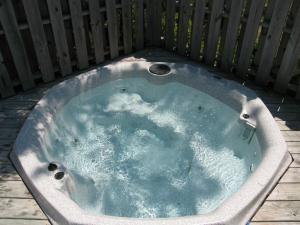 a hot tub in a backyard with a fence at Reminiscent in Nags Head