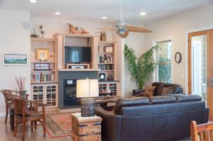 a living room with a blue couch and a tv at Reminiscent in Nags Head