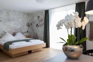 a bedroom with a bed and a vase with white flowers at Dreisam Apartments in Freiburg im Breisgau
