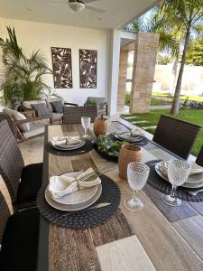Una mesa de madera con platos y copas de vino encima. en Las Terrenas Oasis, en Las Terrenas