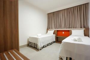 a hotel room with two beds and a window at MOVA Hotéis - Enjoy Olímpia Park Resort in Olímpia