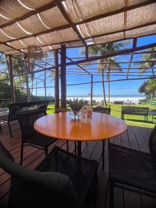 una mesa de madera y sillas en un patio con vistas a la playa en 120 Hotel Boutique - Pé na Areia, en Guarujá