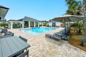 ペンサコーラにあるCoastal Soulのテーブルとパラソルのあるプール