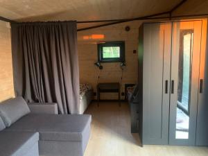 a living room with a couch and a bedroom at Cottage with sauna and kayaks in Hammarland