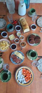 a wooden table with plates of food on it at Bangalô do Pôr do Sol Moreré in Moreré