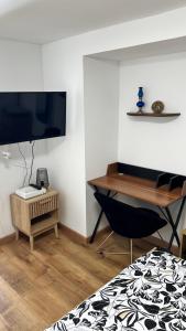 a room with a desk and a television and a chair at Le Minaouët Studio Confort Gare Rosporden in Rosporden +11 photos
