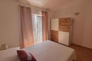 niewielka sypialnia z lodówką i oknem w obiekcie Apartment Vir 10 w mieście Vir
