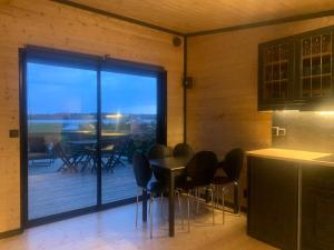 a kitchen with a table and chairs and a balcony at Cottage with sauna and kayaks in Hammarland